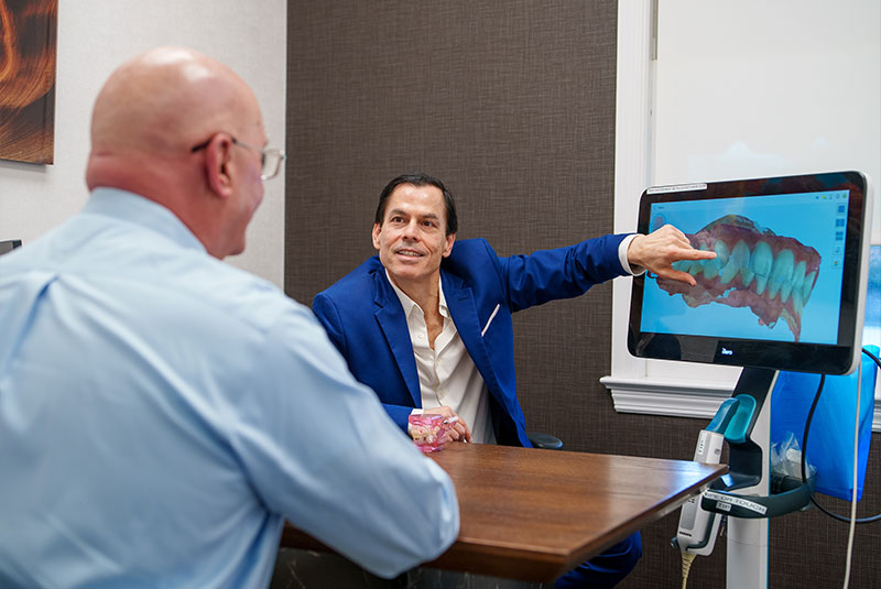 Doctor pointing at model of Patients teeth scan